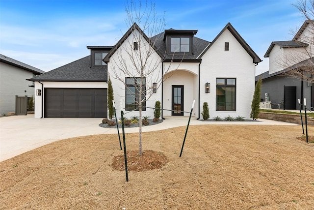 modern farmhouse style home featuring concrete driveway, a garage, and roof with shingles