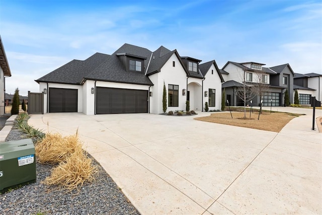 view of front of property featuring stucco siding, driveway, a residential view, roof with shingles, and an attached garage