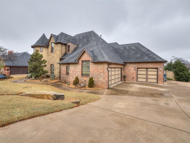 french country inspired facade featuring a garage and a front yard