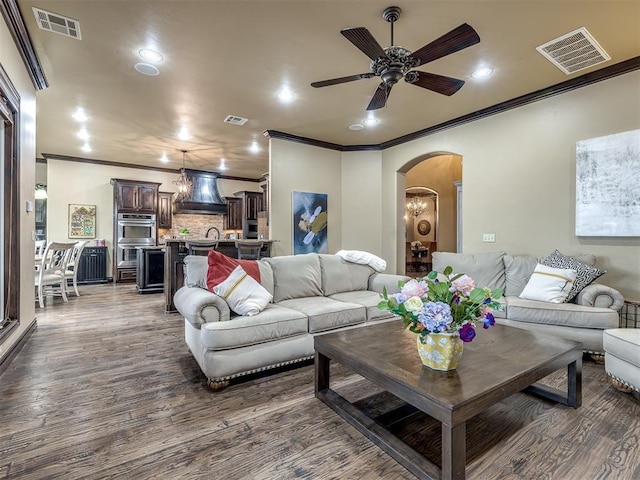 living room featuring ceiling fan, ornamental molding, and dark hardwood / wood-style flooring