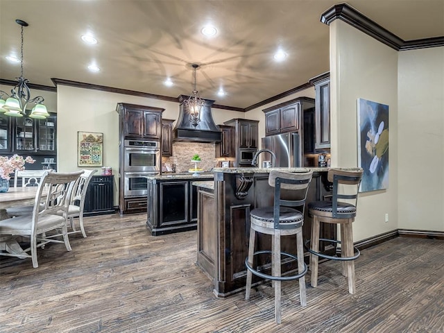 kitchen with stainless steel appliances, dark wood-type flooring, dark brown cabinetry, and decorative light fixtures