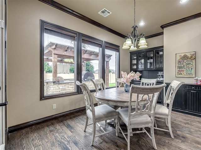 dining room featuring dark hardwood / wood-style flooring, crown molding, and an inviting chandelier