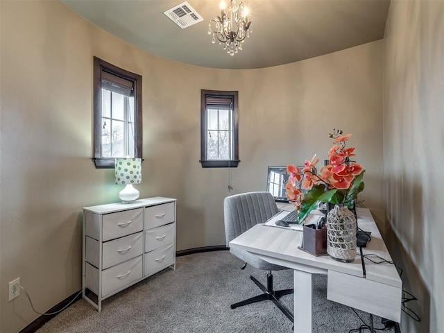 home office with a notable chandelier and light colored carpet