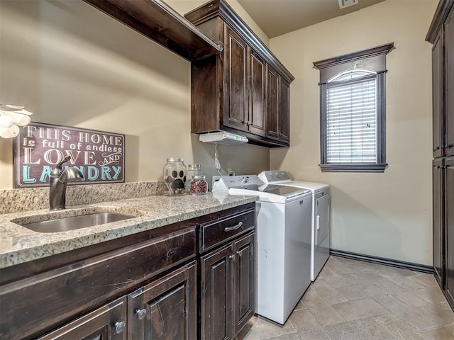 washroom featuring washer and dryer, sink, and cabinets