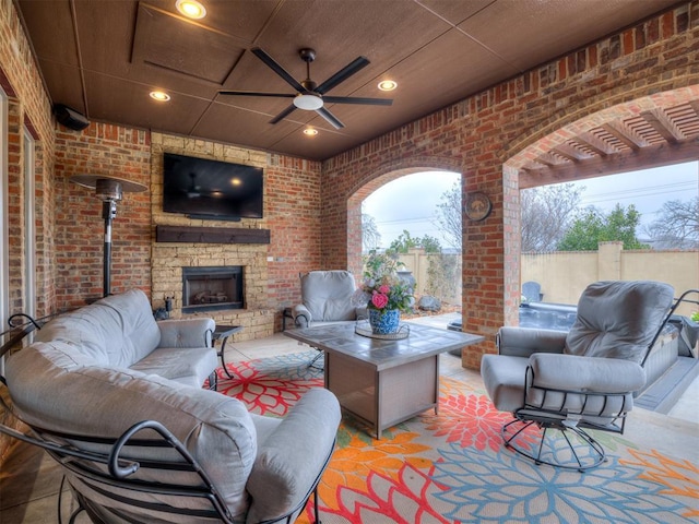 view of patio with ceiling fan and an outdoor living space with a fireplace