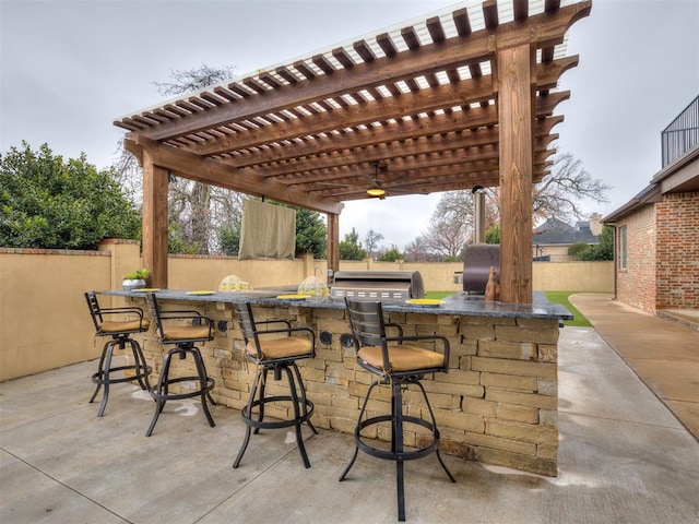 view of patio with area for grilling, a pergola, an outdoor kitchen, and exterior bar