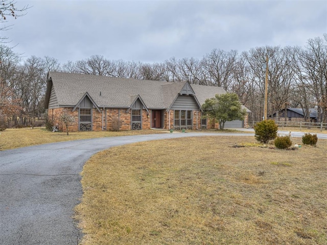 tudor home featuring a garage and a front yard