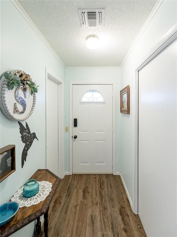 entryway with crown molding, dark wood-type flooring, and a textured ceiling