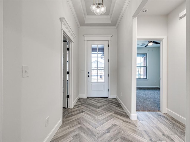 entryway with an inviting chandelier, ornamental molding, and light parquet floors