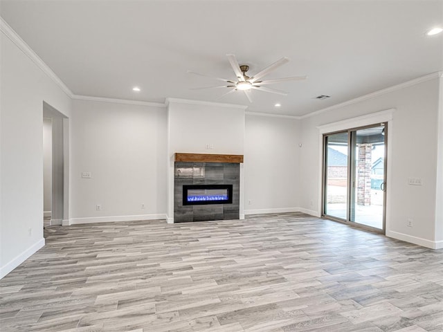 unfurnished living room featuring ceiling fan, ornamental molding, a fireplace, and light wood-type flooring