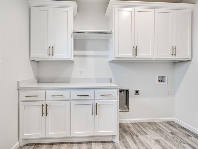 clothes washing area featuring cabinets, hookup for an electric dryer, hookup for a washing machine, and light hardwood / wood-style flooring