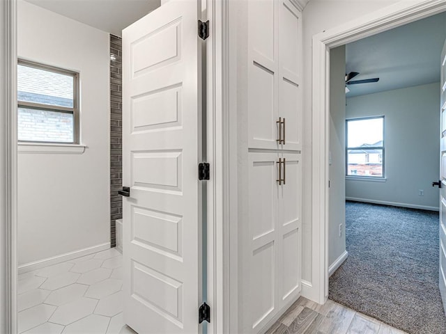 hall with light colored carpet