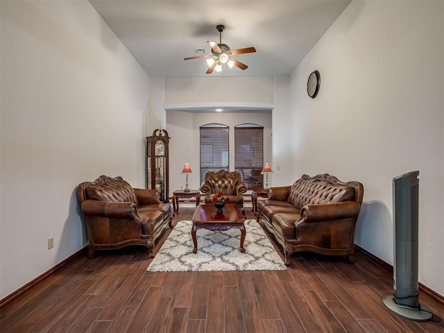 living room featuring dark wood-type flooring and ceiling fan