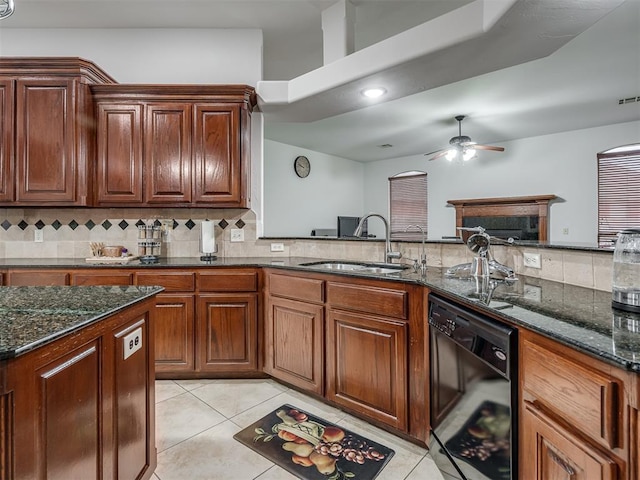 kitchen featuring sink, decorative backsplash, dark stone counters, and dishwasher