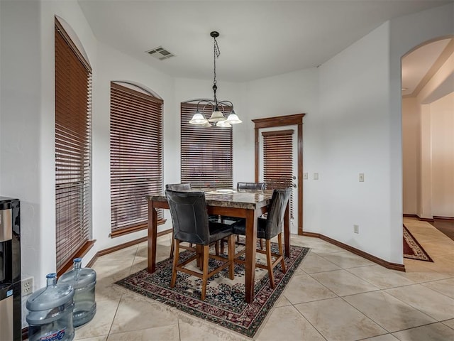 tiled dining room featuring a notable chandelier