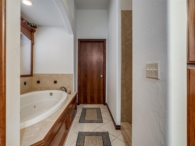 bathroom with tile patterned floors and tiled bath