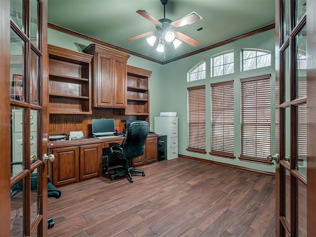 office featuring french doors, dark wood-type flooring, crown molding, built in desk, and ceiling fan