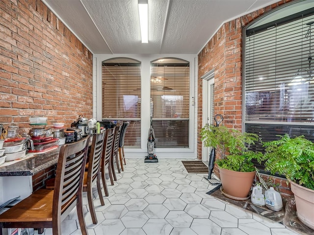 interior space with brick wall and a textured ceiling