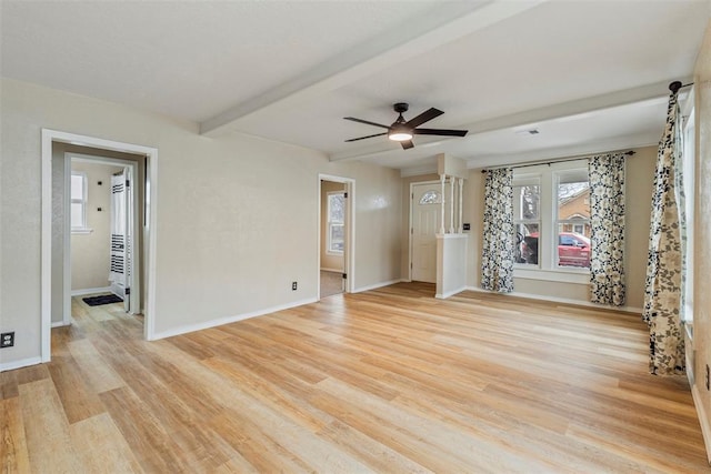 unfurnished living room featuring beamed ceiling, ceiling fan, and light wood-type flooring