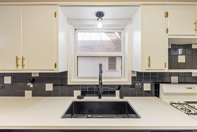 kitchen with white cabinetry, sink, and backsplash