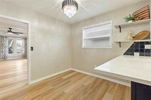 dining area featuring ceiling fan with notable chandelier and light wood-type flooring