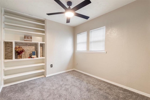 unfurnished room with ceiling fan and carpet