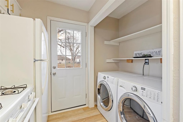 clothes washing area featuring washer / clothes dryer and light hardwood / wood-style floors