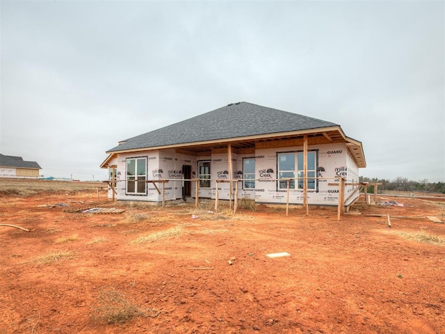 rear view of house with a shingled roof