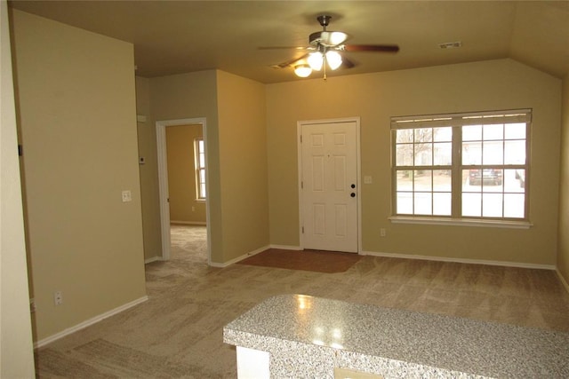 foyer entrance with visible vents, baseboards, a ceiling fan, and carpet flooring