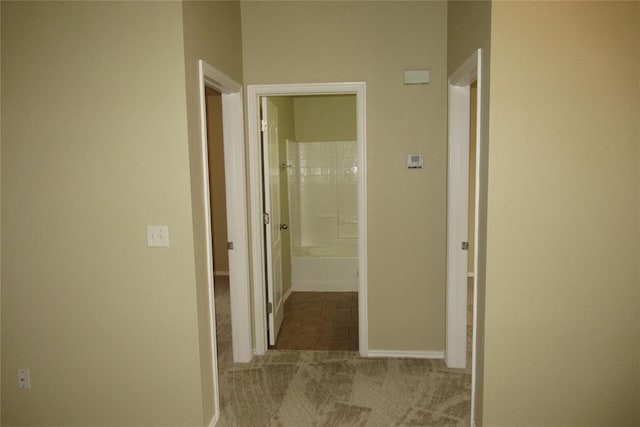 hall with baseboards and carpet