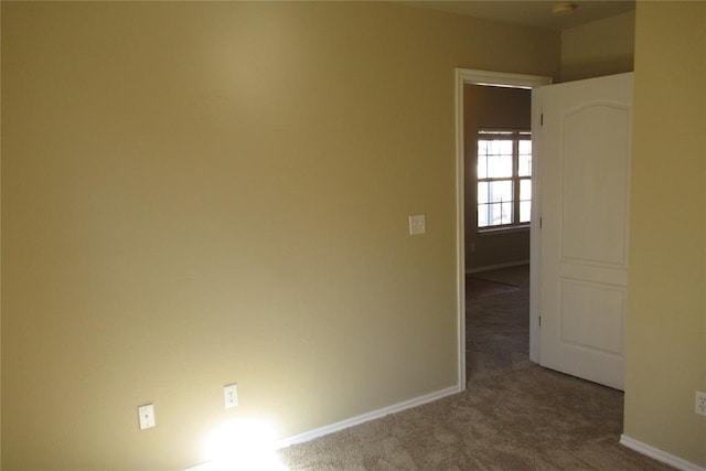 carpeted empty room featuring baseboards