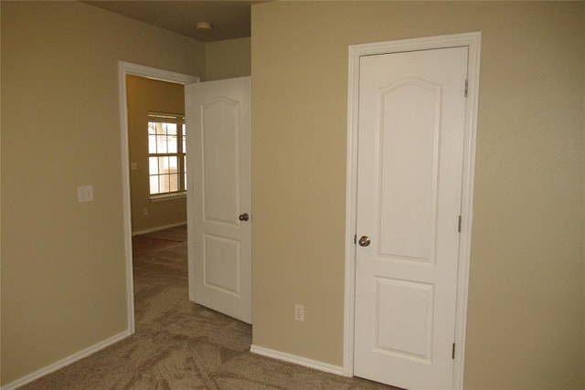 unfurnished bedroom featuring baseboards and carpet flooring