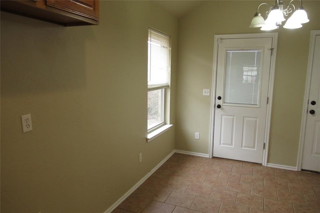 doorway with baseboards, a notable chandelier, light tile patterned flooring, and vaulted ceiling