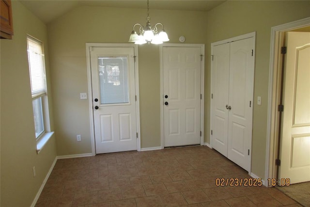 interior space with vaulted ceiling, a notable chandelier, baseboards, and tile patterned floors