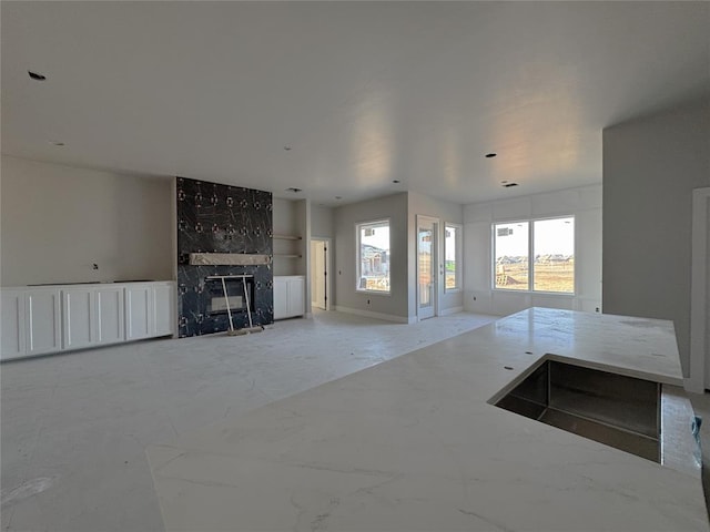 unfurnished living room featuring a high end fireplace