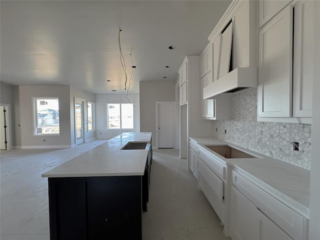 kitchen featuring white cabinetry, a center island, black electric cooktop, decorative backsplash, and wall chimney range hood