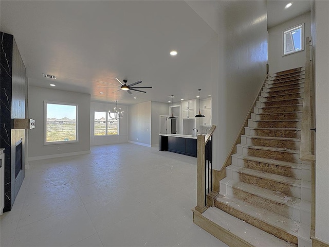7225 NW 154th St, Edmond, OK 73013 - stairs with baseboards, visible vents, recessed lighting, ceiling fan with notable chandelier, and a fireplace