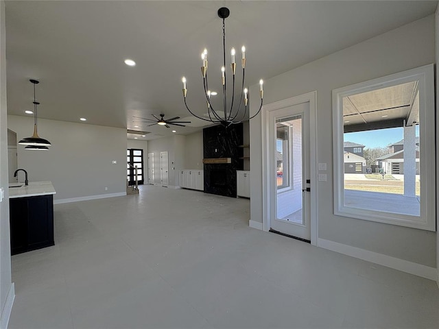 7225 NW 154th St, Edmond, OK 73013 - interior space with ceiling fan with notable chandelier, baseboards, a sink, and plenty of natural light