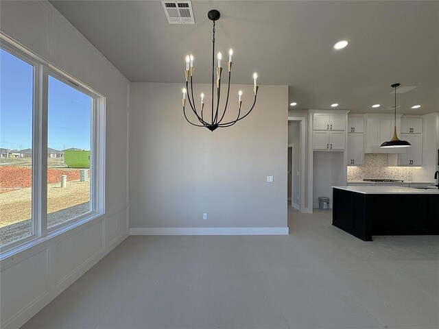 7225 NW 154th St, Edmond, OK 73013 - kitchen with visible vents, backsplash, a notable chandelier, white cabinetry, and light countertops