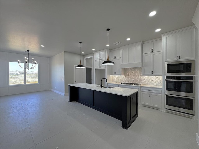 7225 NW 154th St, Edmond, OK 73013 - kitchen with a sink, white cabinetry, a chandelier, backsplash, and appliances with stainless steel finishes