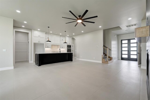 7225 NW 154th St, Edmond, OK 73013 - unfurnished living room with french doors, a ceiling fan, stairs, recessed lighting, and concrete floors
