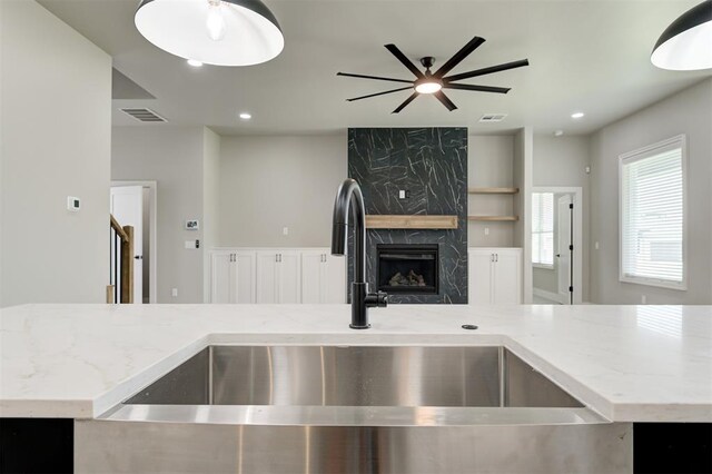 7225 NW 154th St, Edmond, OK 73013 - kitchen with a premium fireplace, light stone counters, a ceiling fan, and recessed lighting