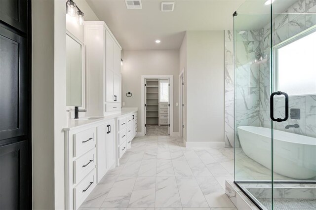 7225 NW 154th St, Edmond, OK 73013 - bathroom featuring marble look tile flooring, vanity, a freestanding bath, recessed lighting, and a walk in closet