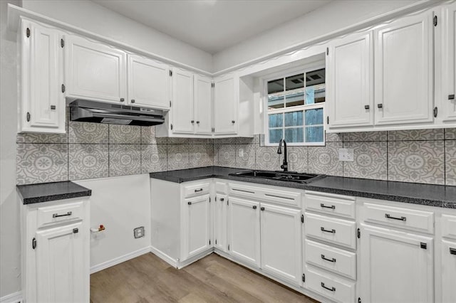 kitchen featuring white cabinetry, sink, tasteful backsplash, and light hardwood / wood-style floors