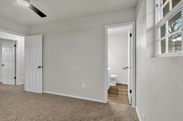 unfurnished bedroom with ceiling fan, connected bathroom, and carpet flooring