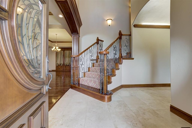 foyer featuring an inviting chandelier and ornamental molding