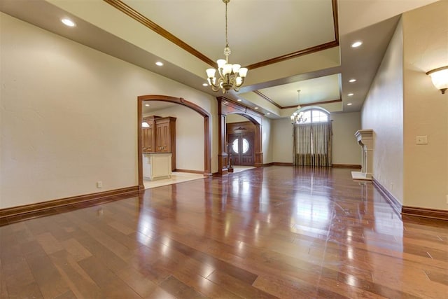 unfurnished room with hardwood / wood-style flooring, crown molding, a notable chandelier, and a tray ceiling