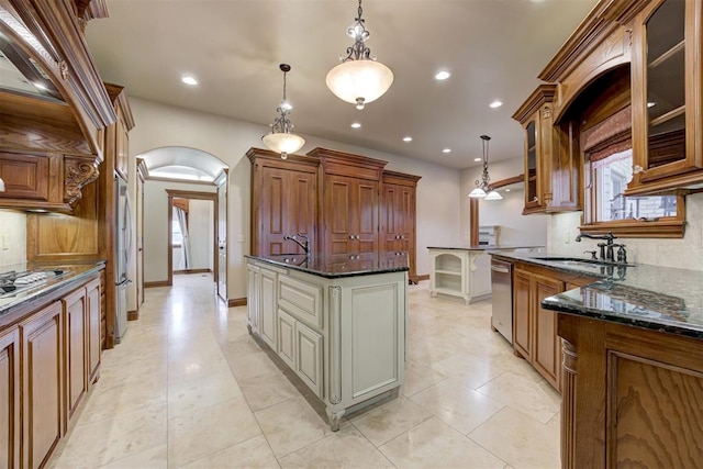 kitchen featuring pendant lighting, sink, dark stone counters, and a kitchen island