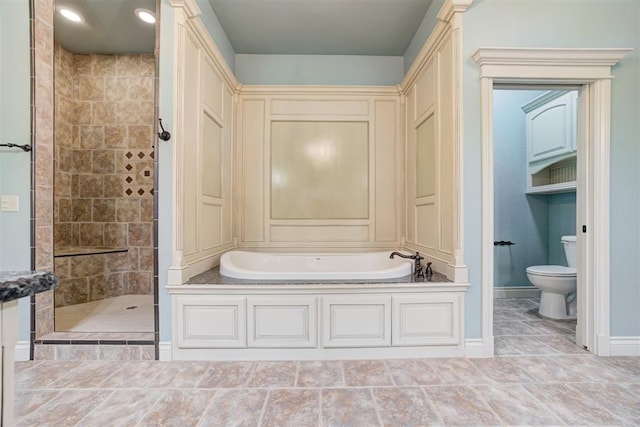 bathroom featuring toilet and separate shower and tub