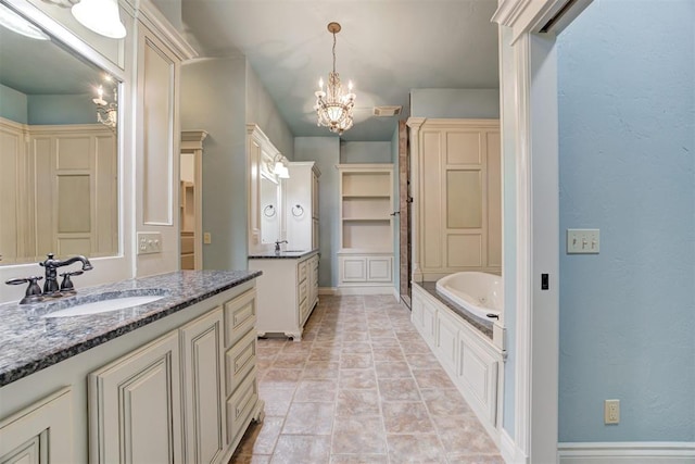 bathroom featuring vanity, a washtub, and an inviting chandelier